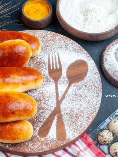 top view tasty dinner rolls fork spoon imprint powdered sugar wood board quail eggs oil bottle turmeric flour bowls table