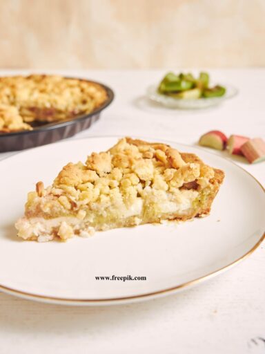 vertical shot of a slice of crispy rhabarbar cake tart on a white plate with some fruits